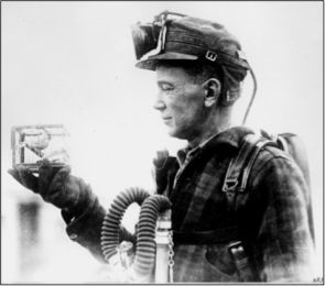 Coal miner holding a canary in a small cage